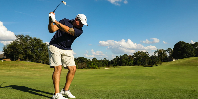 A man hits with a golf club - golf benefits